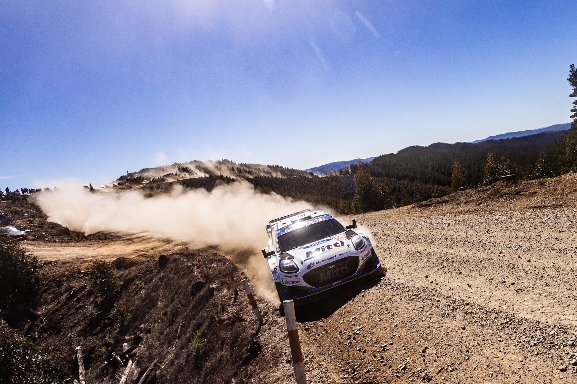 Un Ford Puma Rally1 de M-Sport en un tramo de tierra, con una nube de polvo detrás