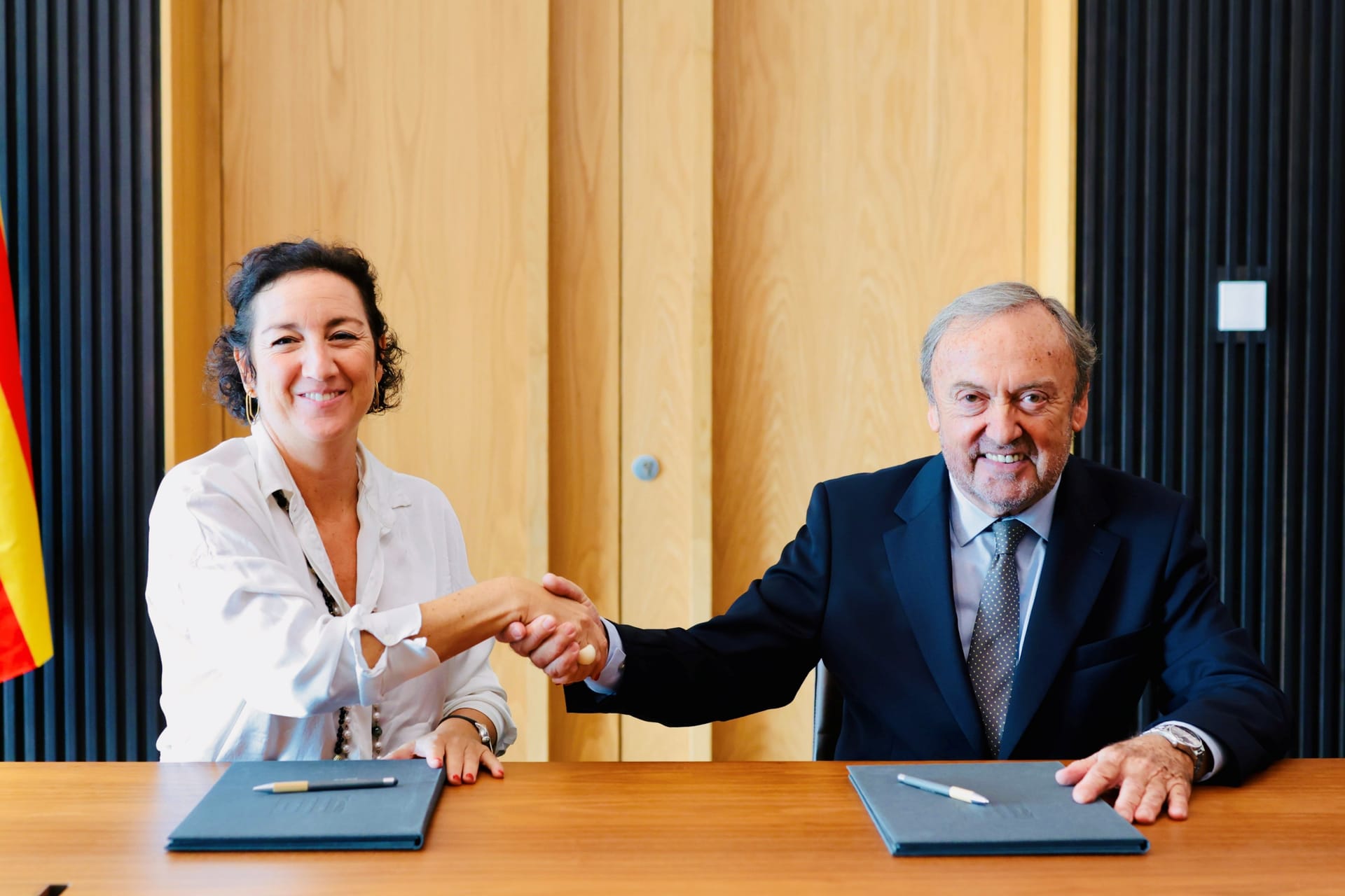 Alícia Romero y Josep Mateu se dan la mano tras firmar el acuerdo de compraventa de la sede del RACC