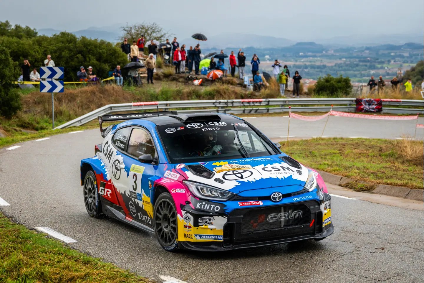 El Toyota GR Yaris Rally2 número 3 de Sergi Francolí y Xevi Moreno en una curva de asfalto, con público al fondo