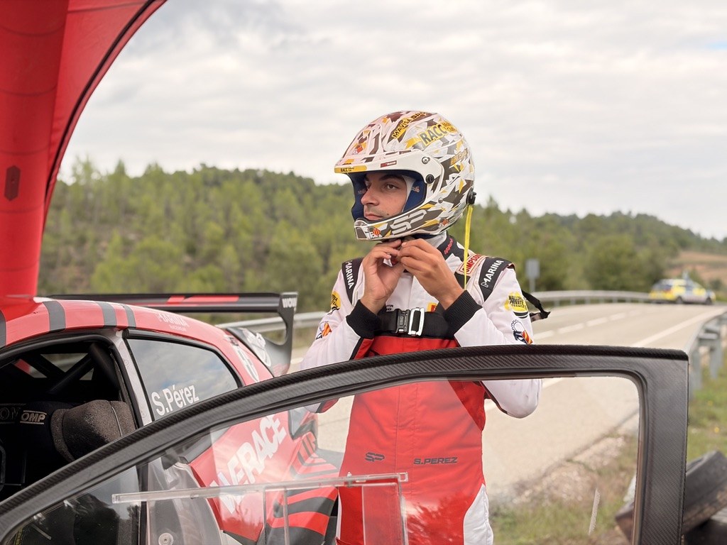 Sergi Pérez se abrocha el casco junto a su Toyota GR Yaris Rally2 en el test previo al RallyRACC