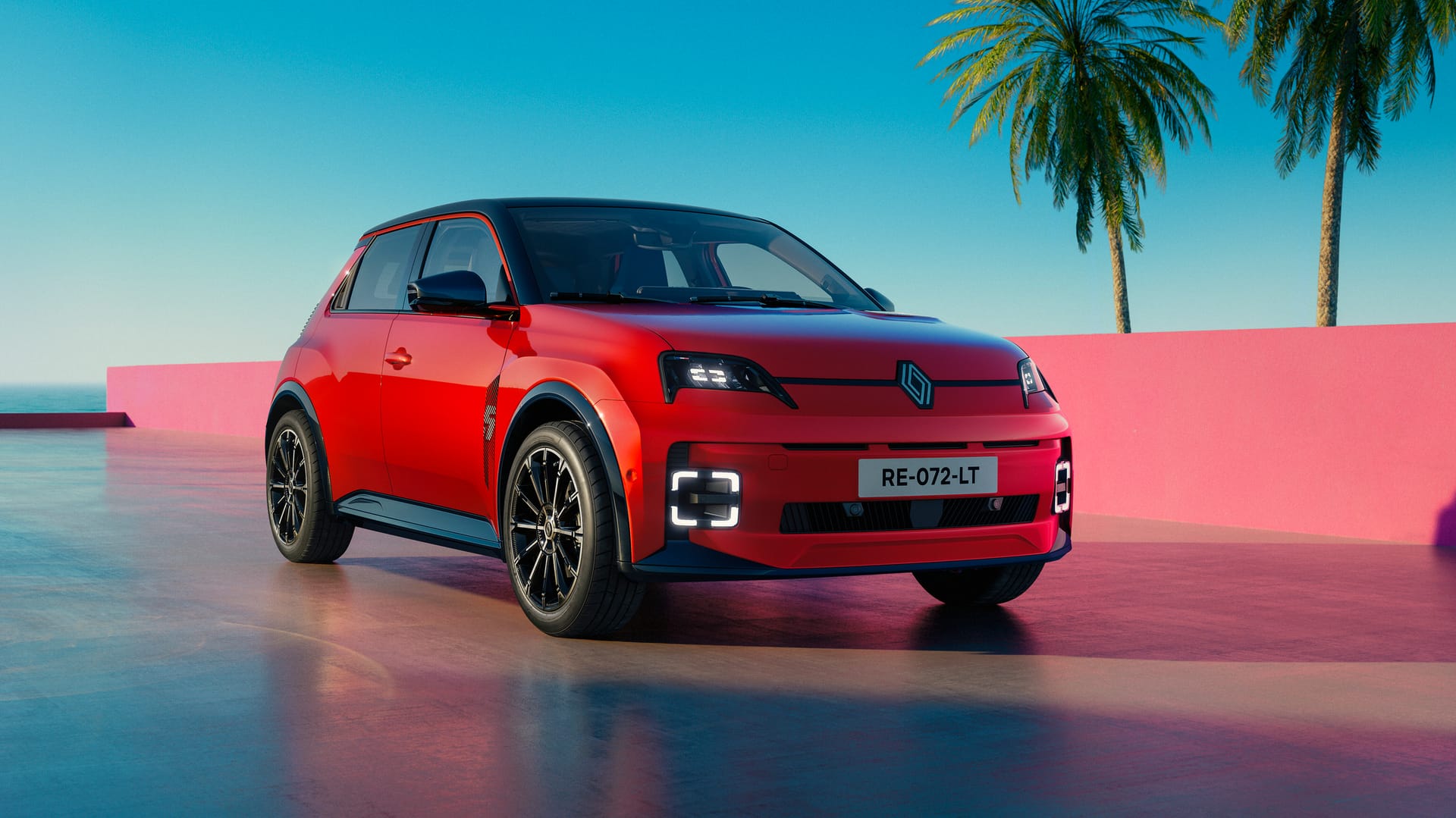 Un Renault 5 E-Tech eléctrico rojo aparcado junto a unas palmeras