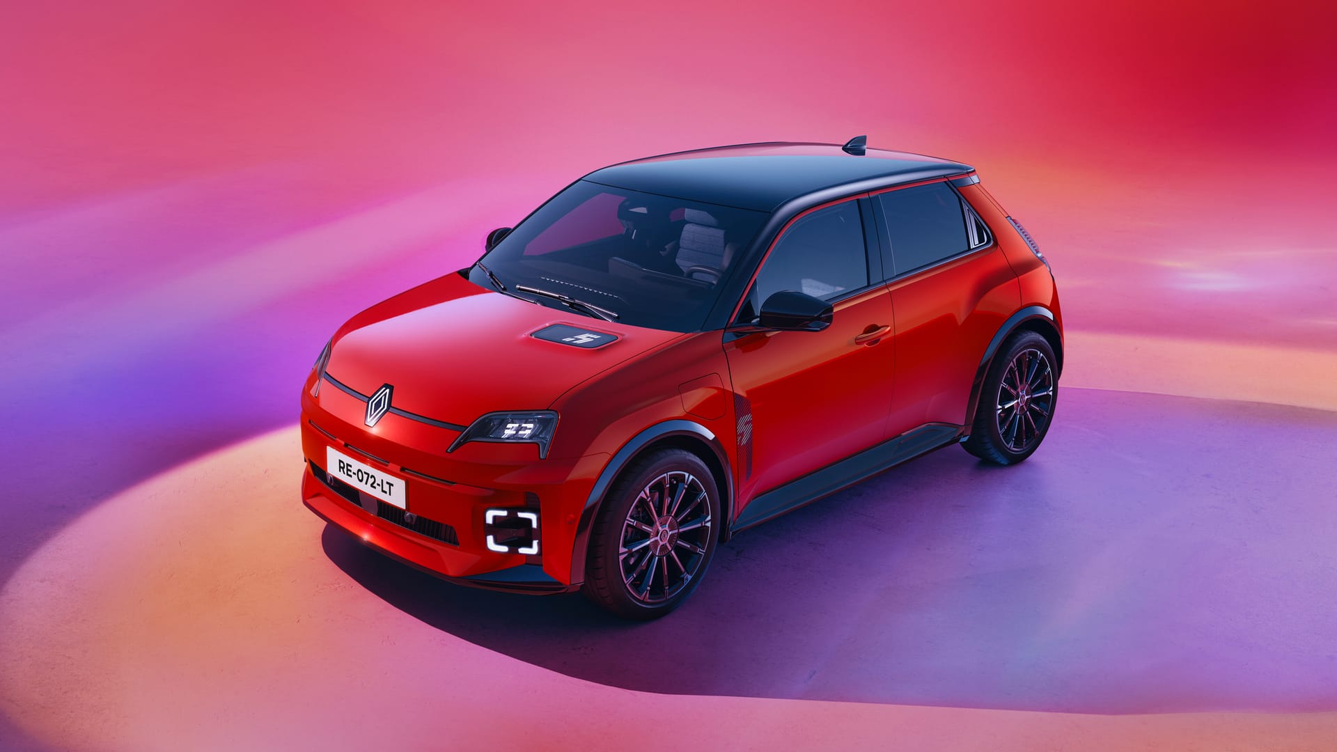 Un Renault 5 E-Tech rojo visto desde arriba, sobre un fondo de colores