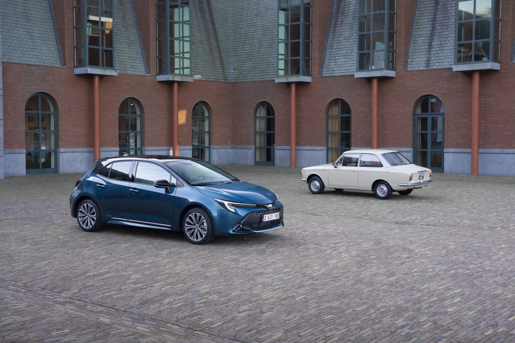 Un Toyota Corolla actual azul junto a un Corolla blanco de primera generación